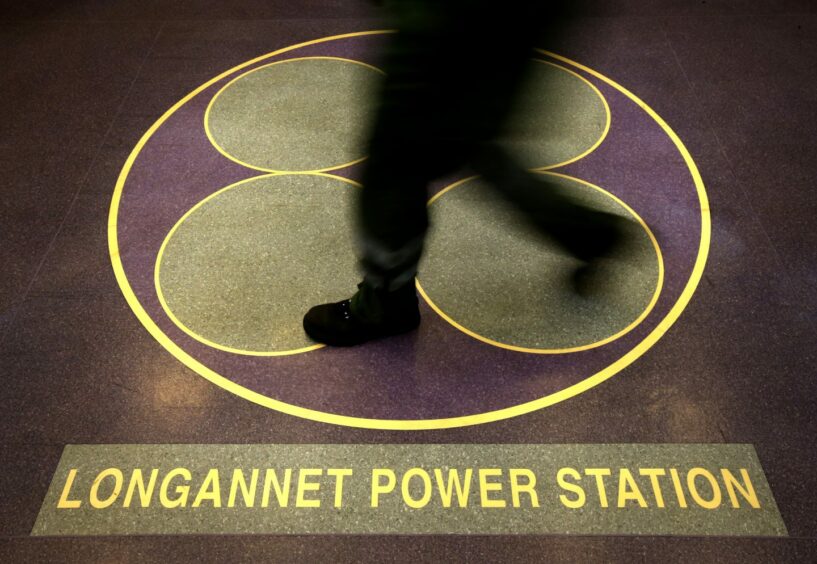 The entrance to the control room, with a sign on the floor reading Longannet Power Station, as workers pass through its corridors for the final time.