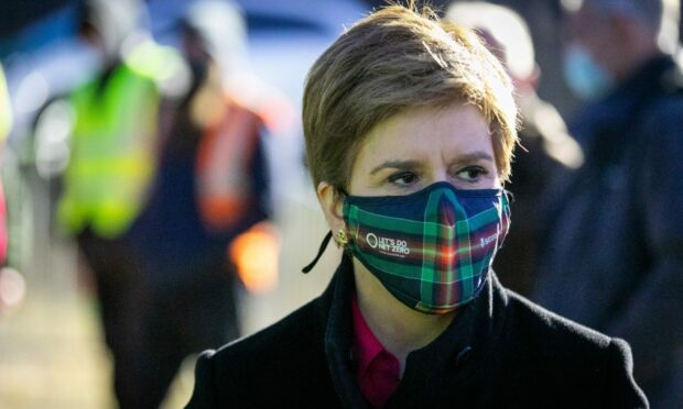 First Minister Nicola Sturgeon wearing a tartan face covering.