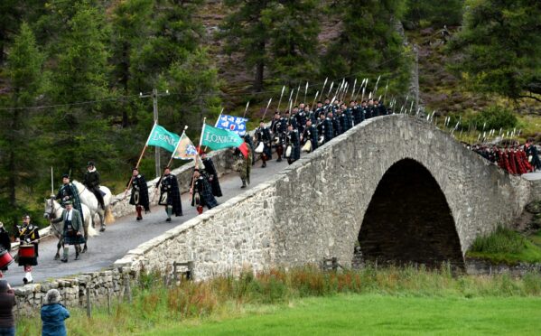 The Lonach Highlanders marching across the current Gairnshiel Bridge, in Aberdeenshire in 2015, which is in need of repairs