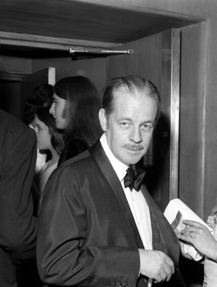 Alistair MacLean staring down the camera in a tux