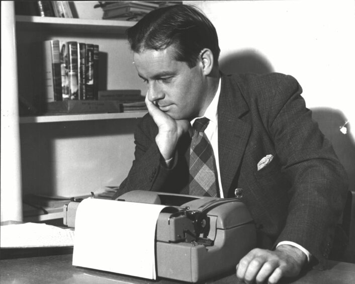 Alistair MacLean sitting at his typewriter