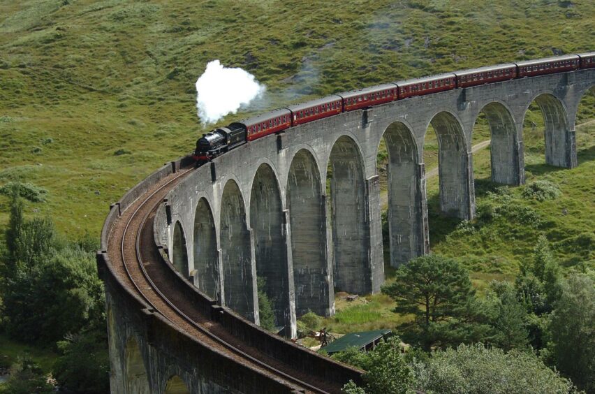 An image showing a steam train moving across the Glenfinnan Viaduct