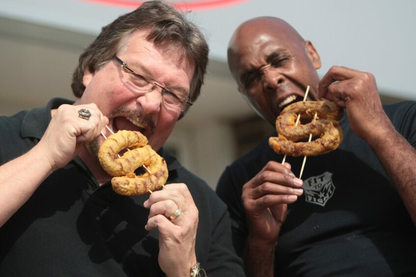 DiBiase and Virgil enjoy the Million Dollar battered sausages which were cooked up at Tony's Takeaway.