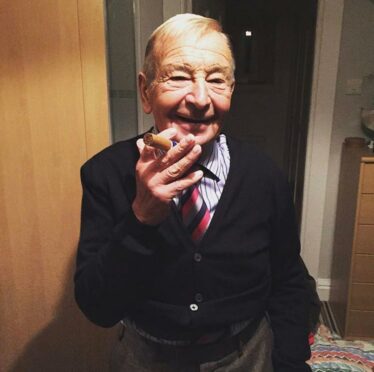 Bill Pennycook laughing while holding a cigar.