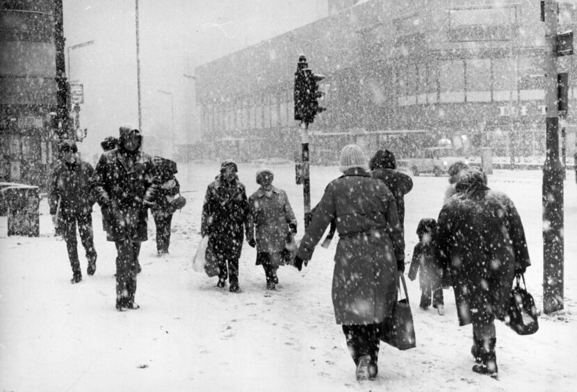 People crossing the road in snowy Dundee.