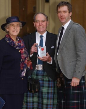 Alistair McCook pictured with wife Sheena and son Sandy at Buckingham Palace.