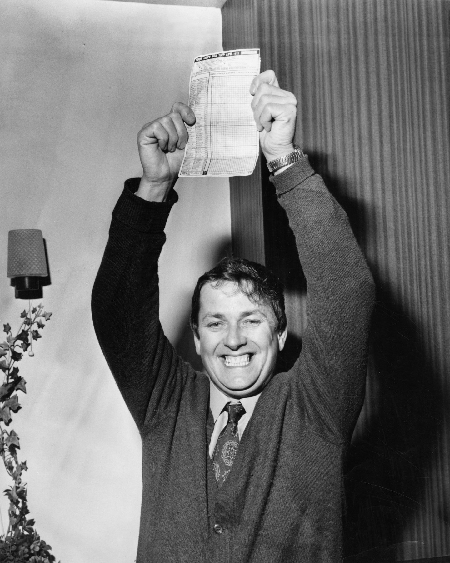 A smiling Harry Yorston holds his coupon above his head, like a trophy