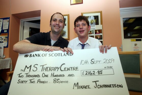 Alwyn Vaughn of the MS Therapy Centre is shown accepting a cheque from Mikael.