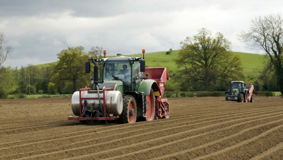 Tractors plough a field