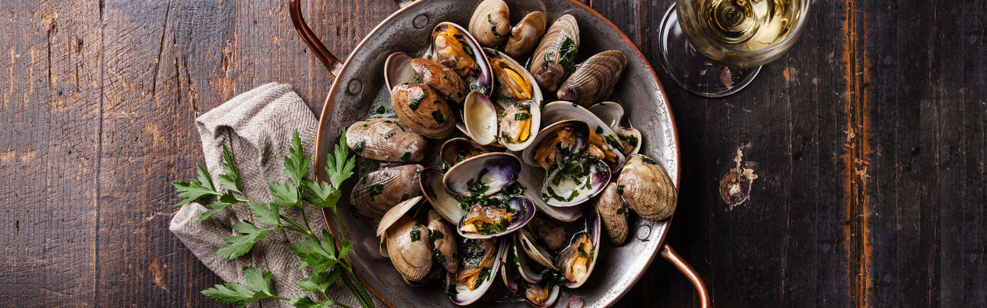 Delicious Mussels A bowl of mussels sitting on a wooden table.