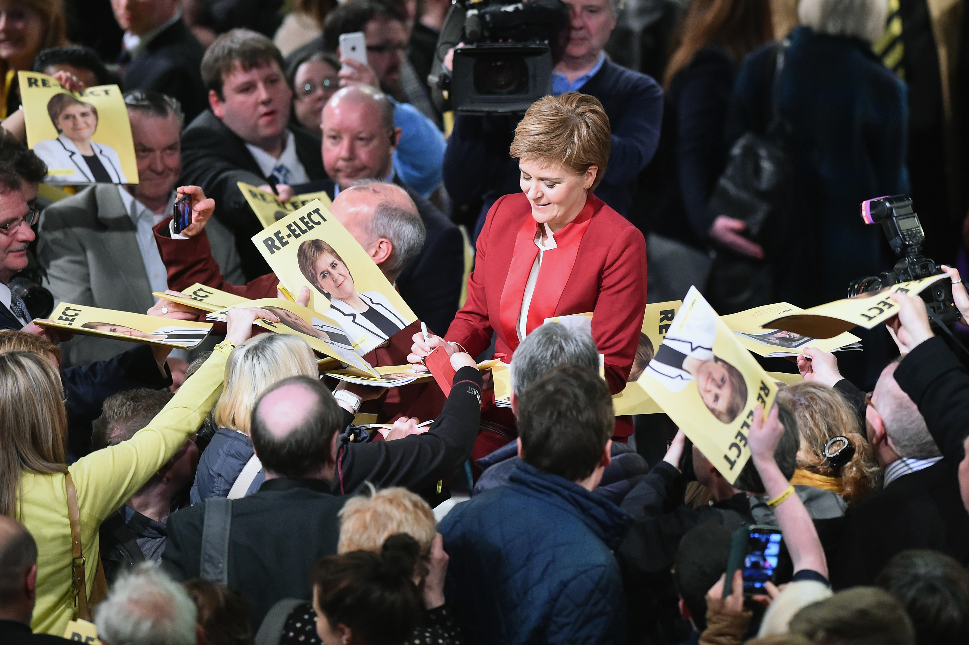Nicola Sturgeon signs manifesto copies and posters during the launch.