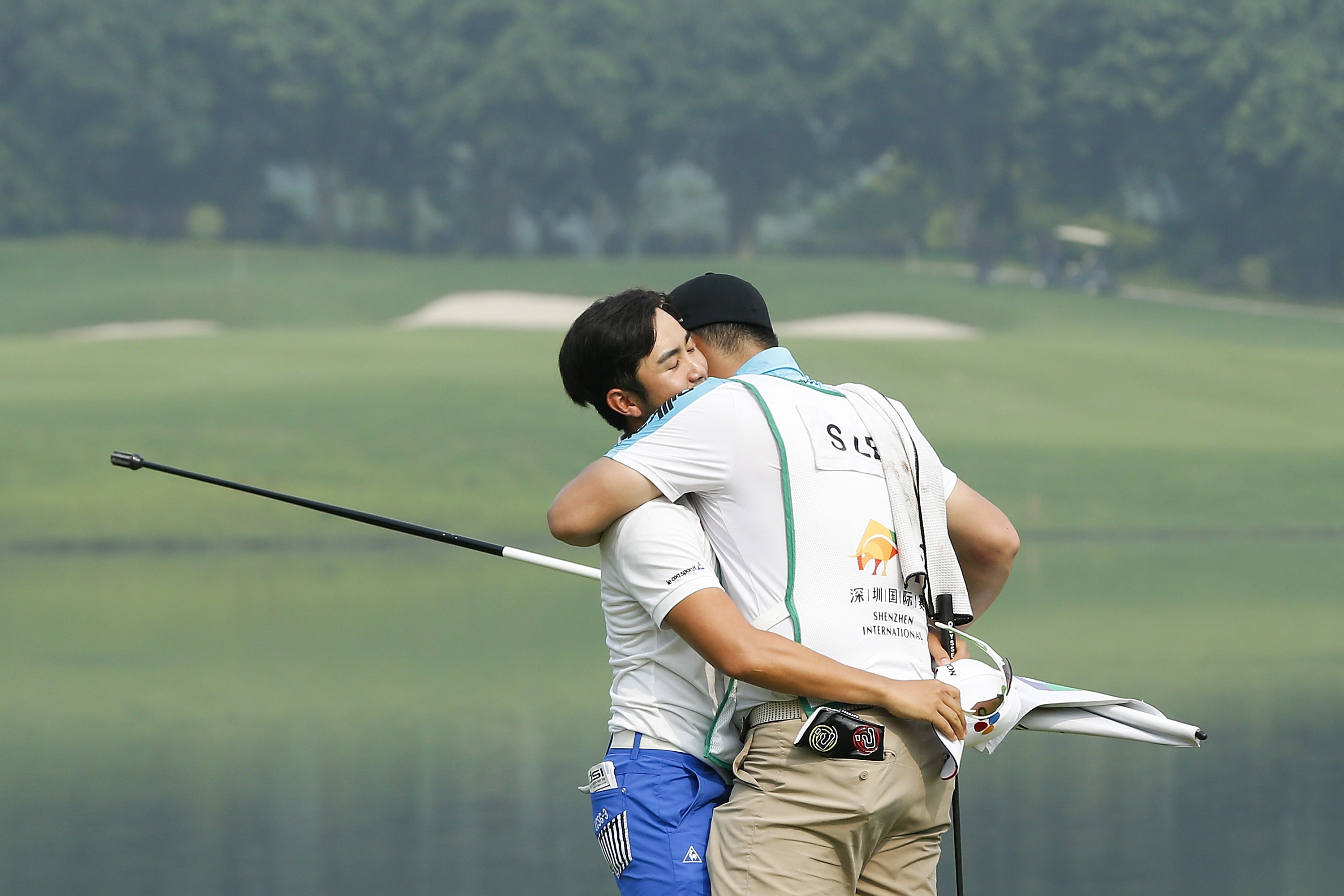 Soomin Lee of South Korea celebrates with his caddy.