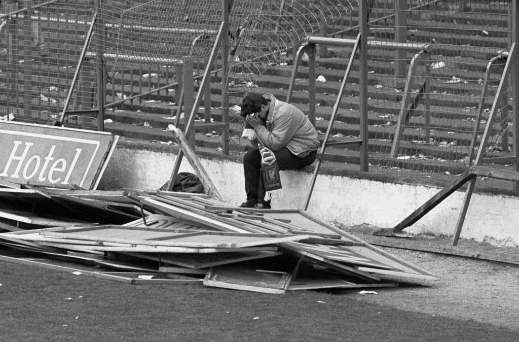 The horror of the Hillsborough disaster is too much for a young Liverpool fan, who sits with his head in his hands amid the wrecked fencing at the stadium