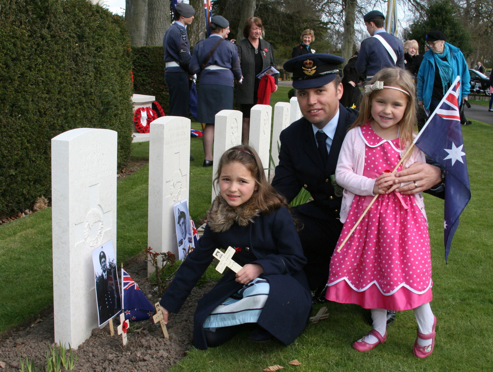 Squadron Leader Stuart McLean of the Australian Air Force was joined by his two children Georgia, 7, and Chloe, 4, in placing a cross at a grave.