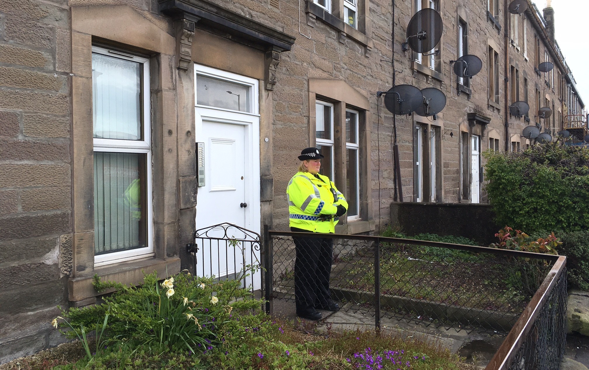 A police officer stands outside the home in Dunkeld Road where a woman was found dead.