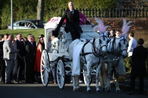 Mourners walk behind a horse drawn hearse carrying Paiges coffin.