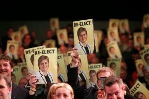 Audience members hold up the SNP's manifesto.