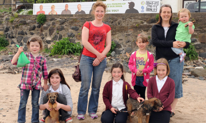 In front of one of the banners are, from left, Corrin, 5, Cara, 10, with Copper, Suzanne and Kaitlin Gilfeather, 8, with Murphy, Chloe, 4, Sophie, 7, and Sarah McMillan with 20-month-old Kirsten.