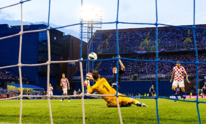 Robert Snodgrass slots the ball home to open the scoring for Scotland.