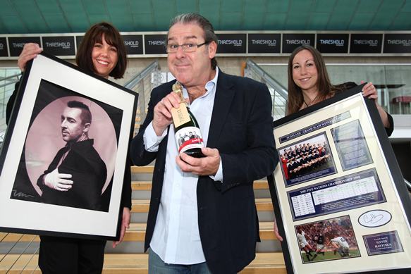 Kris Miller, Courier, 09/08/10, News. Picture today at Perth Concert Hall. Pic shows L/R, Jennie Baillie, Andy Gray and Helen McKinnon with lots from the charity auction which will be held later this month. Items are a signed picture of Alan Cumming, a bottle of Champagne (limited 100 bottles to mark 100th edition of Taggart) with signed box and a signed picture of The Grand Slam winning Scotland Rugby Squad.