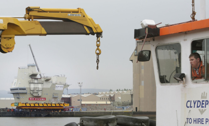 The aft island section is loaded on to a barge at BAE Systems shipyard in Glasgow.