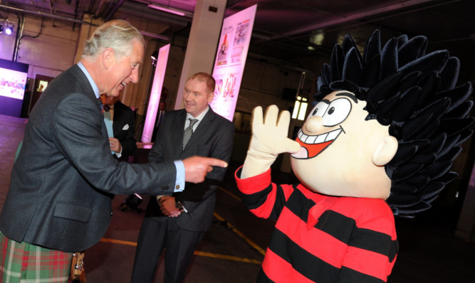 Prince Charles laughs off a joke from Dennis the Menace.