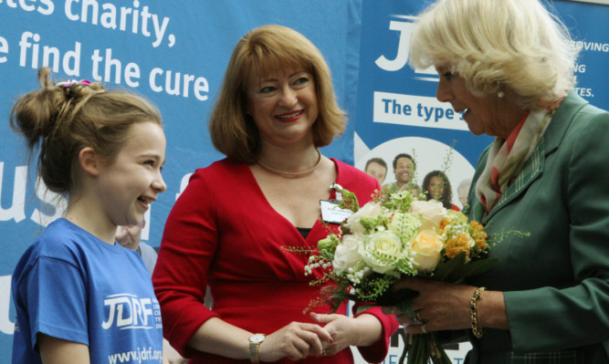 The Duchess receives her posy from Darcey McDonald, watched by JRDF chief executive Karen Addington.