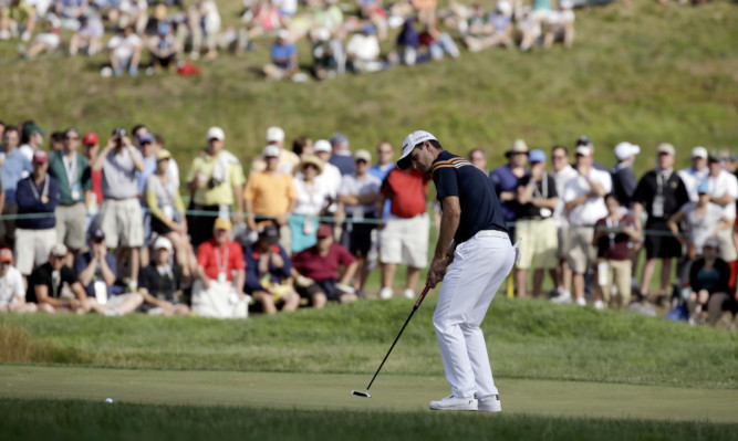 Justin Rose, of England, putts on the fifth green.