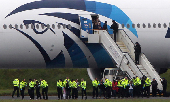 Passengers leave the Egyptair plane after it was diverted to Prestwick Airport during its flight from Cairo to New York.