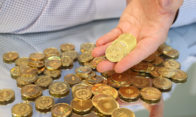 SALT LAKE CITY, UT - APRIL 26: Software engineer Mike Caldwell holds physical Bitcoins he minted in his shop on April 26, 2013 in Sandy, Utah. (Photo by George Frey/Getty Images)