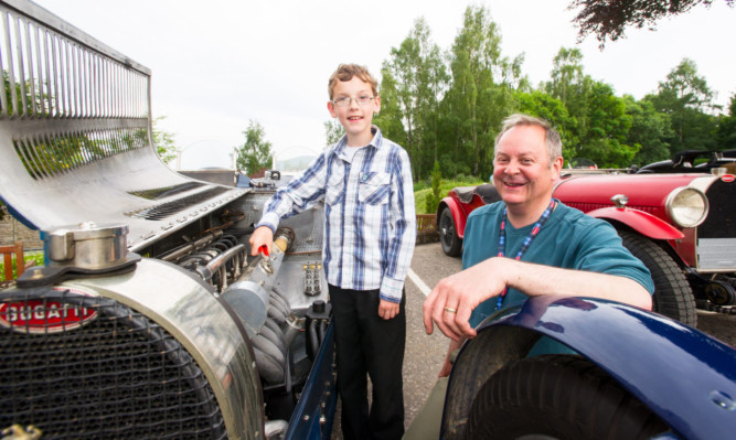 Dylan Wilson, 10,  from Dunkeld, and Colin Bullock of the Bugatti Club UK with some of the classic cars.