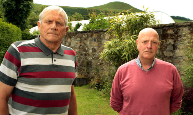 John Todd and Grant Davies with the polytunnel behind Mr Davies garden wall.