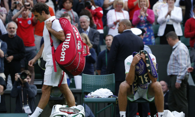 Roger Federer leaves Centre Court as Sergiy Stakhovsky savours the moment.