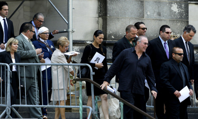 Joe Pantoliano, fifth from left, in white hat, a cast member of "The Sopranos", walks out with a crowd at the Cathedral Church of Saint John the Divine after the funeral service.