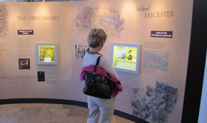 A visitor peruses some of the artefacts on show at the Richard III exhibition at Leicester Cathedral.