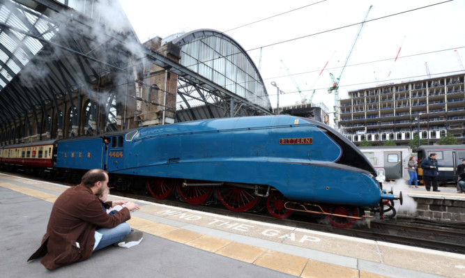 The Bittern steam train which is sister train to the Mallard leaves King Cross in Central London.