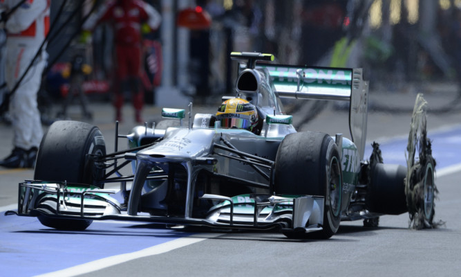 Lewis Hamilton enters the pit after suffering a tyre blowout.