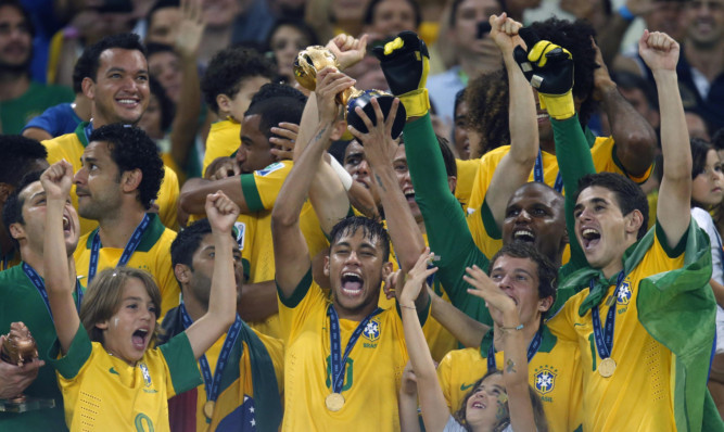 Brazil's Neymar, center, lifts the trophy after winning the Confederations Cup.