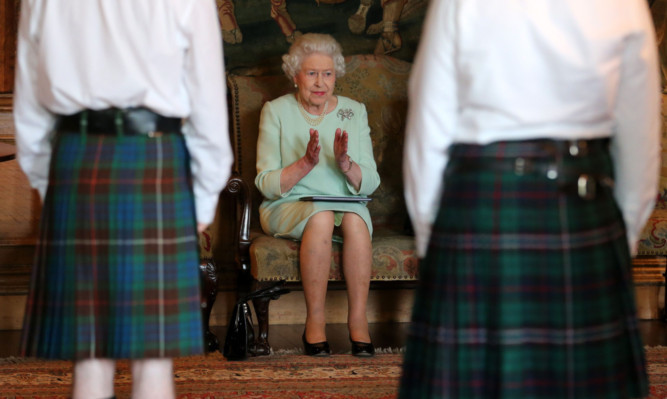 The Queen watches a performance from the Royal Country Dance Society.