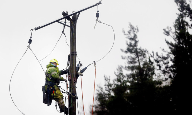 An employee from ScottishPower subcontractors Overlec repairs an overhead powerline near Cumbernauld.