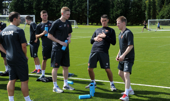 Chris Erskine, centre, chats with his new team-mates during a break in training.