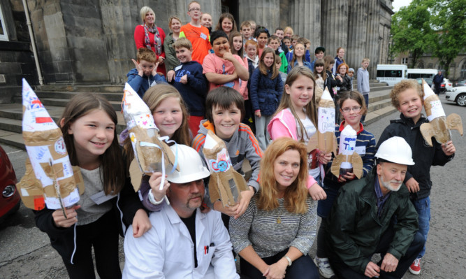 Front, from left: technician Gerry High, Patricia Tribe and technician Bob Campbell. Back: Charley Fotheringham, Chloe Falconer, James Peart, Mia Williams, Lucy Angus and Jon Hamilton, along with other youngsters.