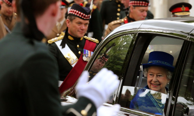 The Queen  smiles as she leaves Dreghorn Barracks in Edinburgh after presenting the Royal Regiment of Scotland, with a Pipe Banner.