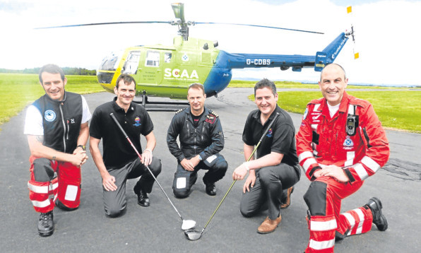 Liam Mowat, second left, and Stuart Leslie, second right, with Scotlands Charity Air Ambulance crew, from left, paramedic Wayne Auton, pilot John Stupart and lead paramedic John Pritchard.