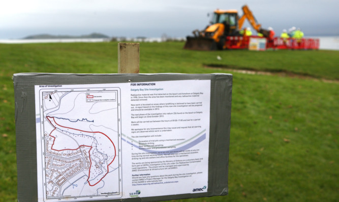 Kris Miller, Courier, 23/10/12. Picture today at Dalgety Bay, Fife where work was under way to dig boreholes to test subsoil/sand for radiation. Pic shows a warning sign with workers in background.