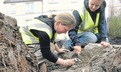 Archaeologists Claire Casey and Caroline George uncover male skeletal remains at the site.