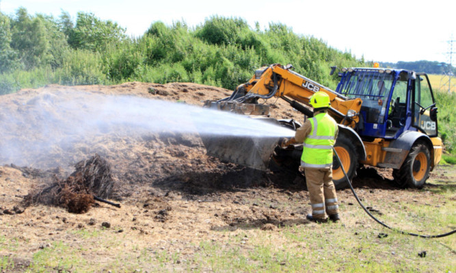 Firefighters tackling the manure heap blaze.