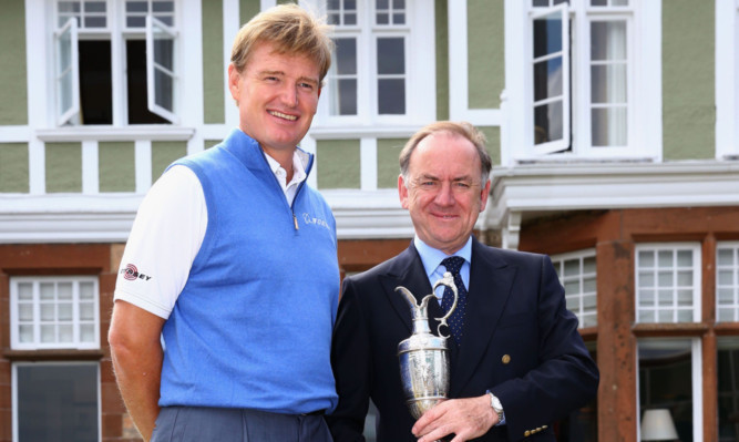 Defending Open champion Ernie Els returns the Claret Jug to Peter Dawson, chief executive of the R&A.