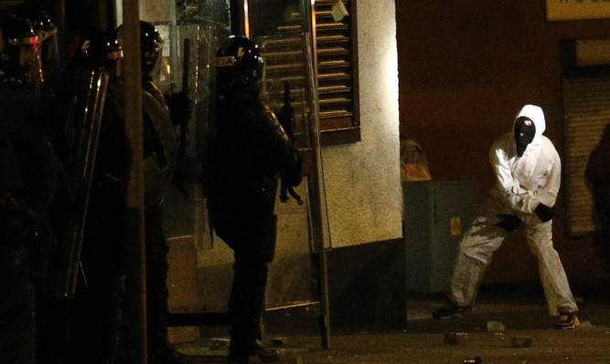 A loyalist rioter attacks riot police in the Woodvale area of north Belfast on Monday night.