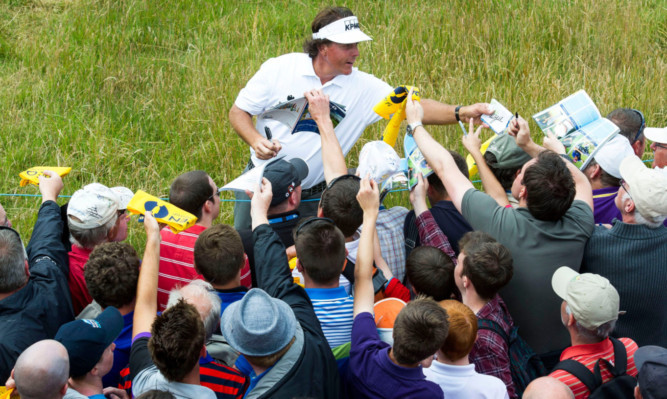 Phil Mickelson stops to sign autographs during Tuesday's practice.